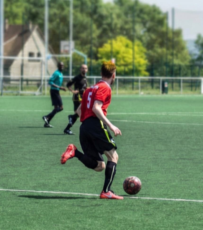 Coach mental el8vate : Ancien joueur de football en action, illustrant l'expérience terrain et la gestion du stress en compétition.